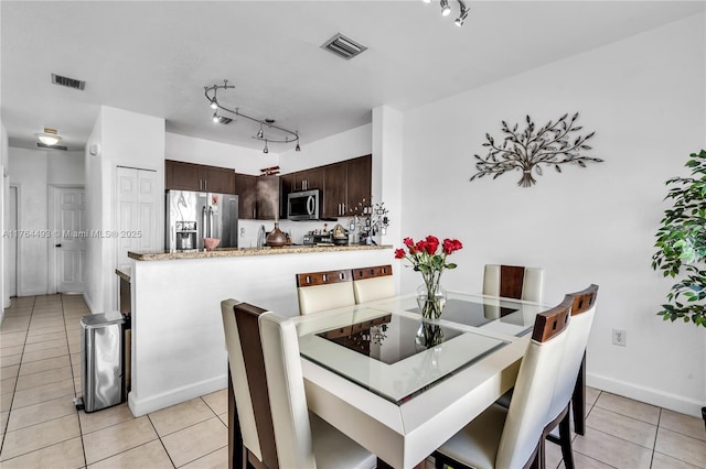 dining area featuring visible vents, light tile patterned flooring, and rail lighting