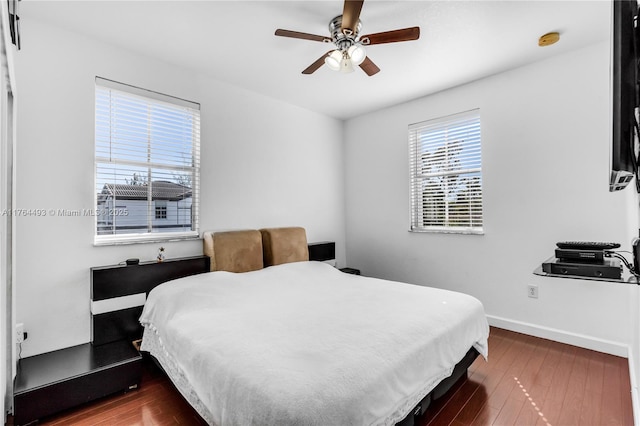 bedroom with ceiling fan, baseboards, and wood finished floors