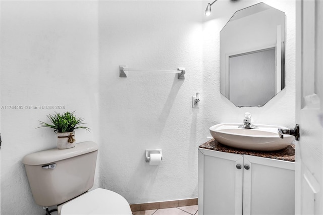 bathroom with baseboards, toilet, vanity, and tile patterned flooring