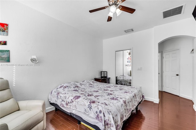 bedroom with visible vents, arched walkways, baseboards, and hardwood / wood-style flooring