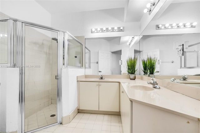 full bathroom featuring tile patterned flooring, a shower stall, double vanity, and a sink