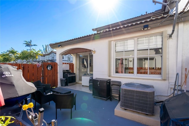 view of patio / terrace with central air condition unit, area for grilling, and fence