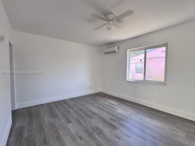 unfurnished room featuring a wall mounted AC, dark wood-style floors, baseboards, and ceiling fan