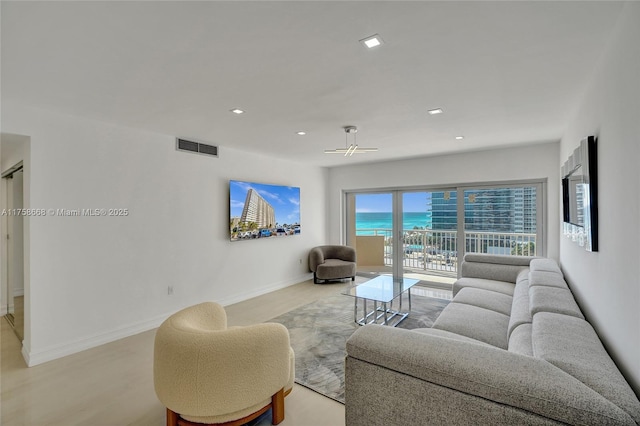 living area with visible vents, recessed lighting, light wood-type flooring, and baseboards