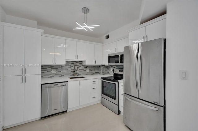 kitchen with light countertops, decorative backsplash, stainless steel appliances, white cabinetry, and a sink