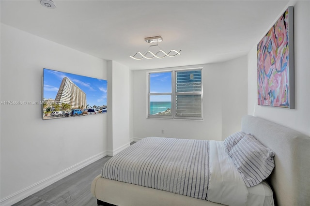 bedroom featuring baseboards and wood finished floors