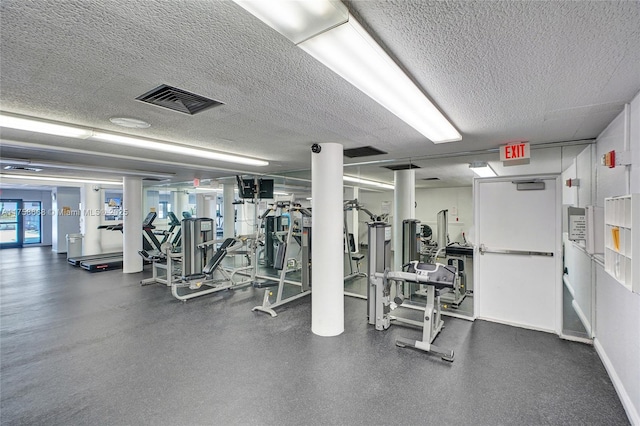 workout area featuring visible vents, baseboards, and a textured ceiling