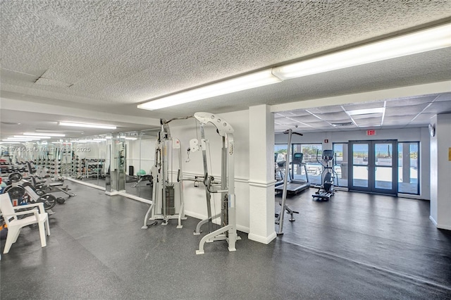 gym with a textured ceiling and baseboards