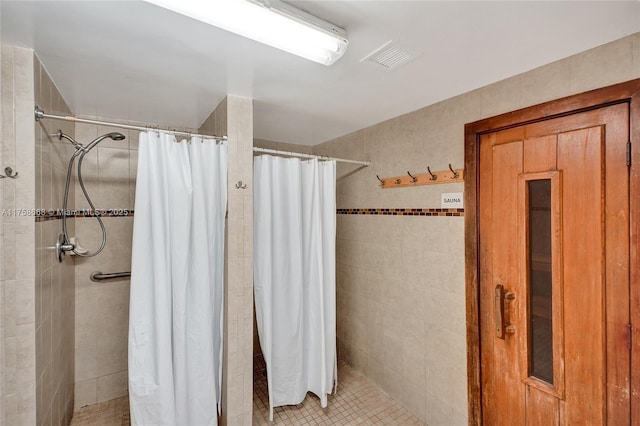 bathroom with visible vents and a shower stall