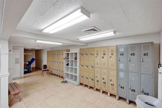 interior space featuring light tile patterned floors, visible vents, and a textured ceiling