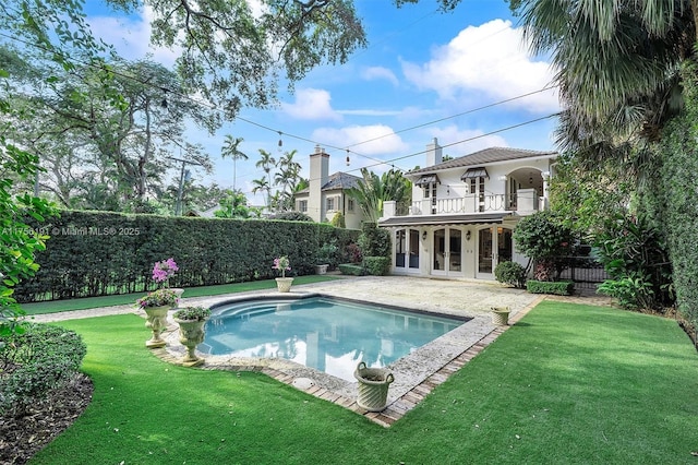 view of pool featuring a lawn, fence, french doors, a fenced in pool, and a patio area