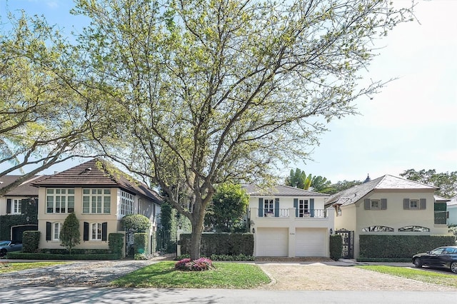 view of front of home featuring fence, an AC wall unit, stucco siding, a garage, and driveway