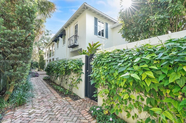 view of property exterior with a gate, a fenced front yard, and stucco siding