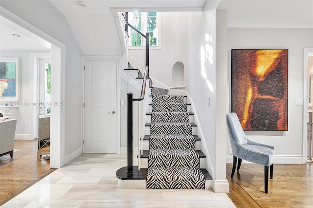 staircase with wood finished floors and baseboards