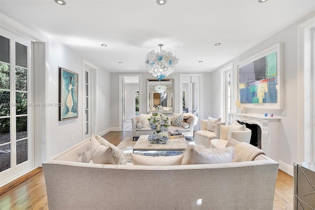 living room featuring recessed lighting, plenty of natural light, light wood-style floors, and a fireplace