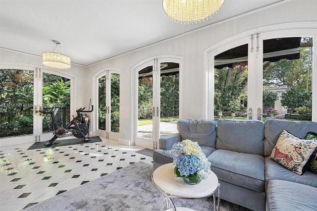 sunroom featuring a notable chandelier, french doors, and a wealth of natural light