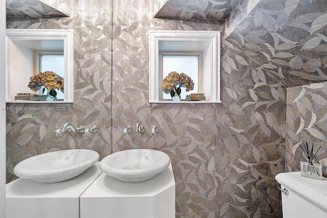 bathroom with vanity, toilet, a healthy amount of sunlight, and wallpapered walls