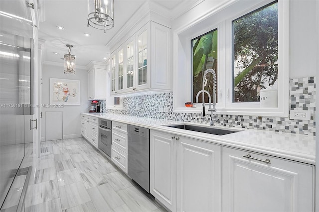 kitchen featuring a sink, light countertops, appliances with stainless steel finishes, white cabinetry, and a chandelier