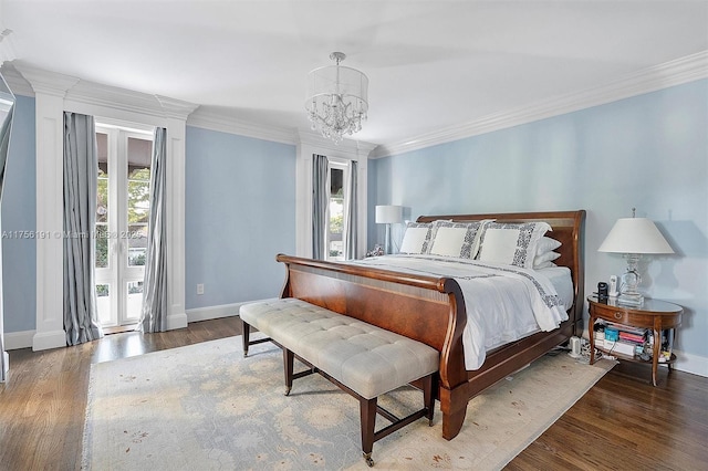 bedroom with baseboards, an inviting chandelier, wood finished floors, and ornamental molding