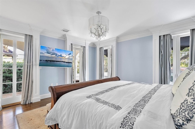 bedroom featuring access to exterior, multiple windows, crown molding, and an inviting chandelier