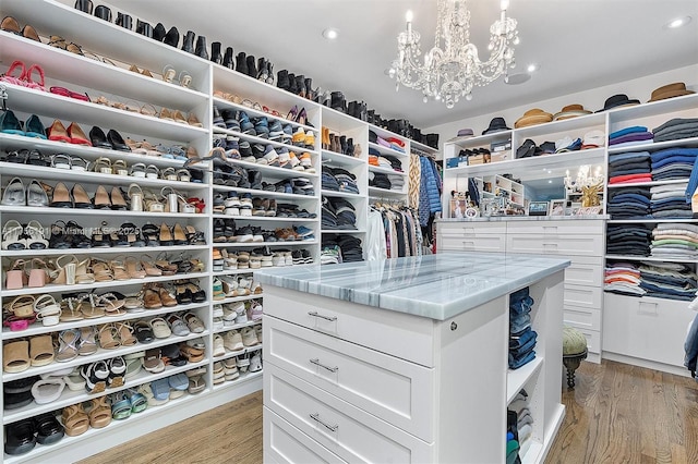 walk in closet featuring light wood-type flooring and a chandelier