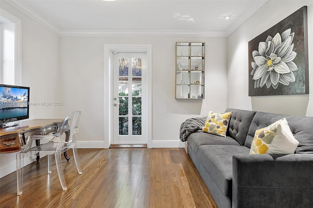 living room featuring wood finished floors, baseboards, and ornamental molding