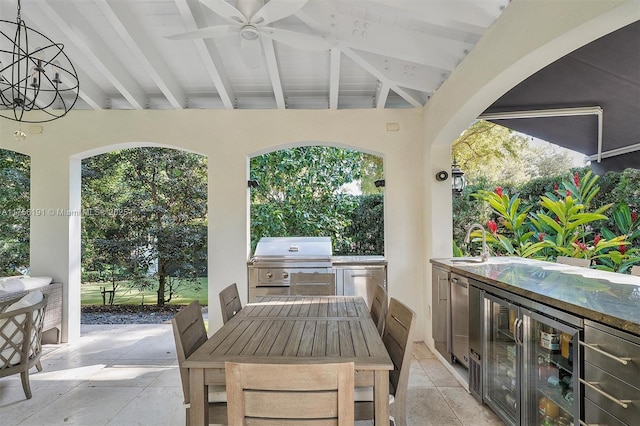 view of patio / terrace featuring wine cooler, area for grilling, an outdoor kitchen, a ceiling fan, and a sink