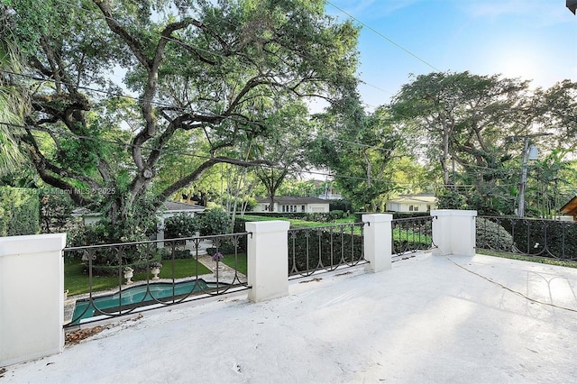 view of gate with a patio, a fenced in pool, and fence