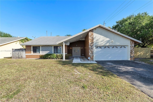 view of front of house with a garage, a front lawn, driveway, and fence