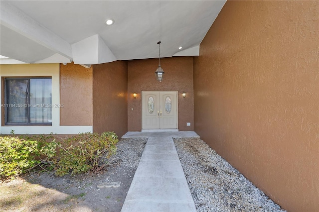 doorway to property featuring stucco siding