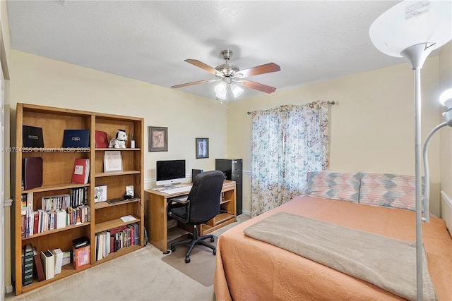 bedroom with carpet flooring, a textured ceiling, and a ceiling fan