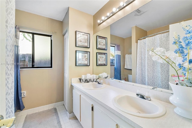 bathroom with tile patterned flooring, visible vents, baseboards, and a sink