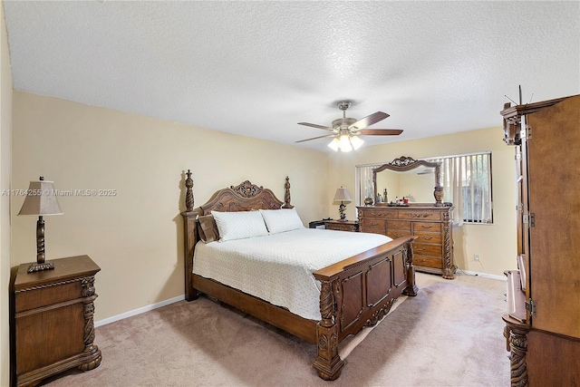 bedroom with light carpet, ceiling fan, a textured ceiling, and baseboards