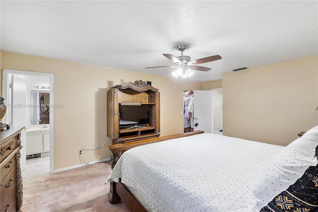 bedroom featuring visible vents, baseboards, ceiling fan, light colored carpet, and ensuite bathroom