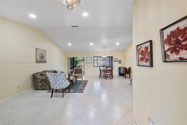 living area featuring baseboards, a chandelier, light tile patterned flooring, and vaulted ceiling