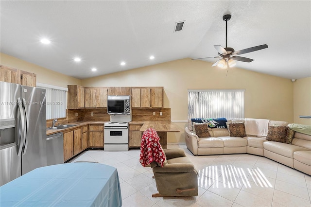 kitchen featuring a ceiling fan, open floor plan, appliances with stainless steel finishes, and a sink