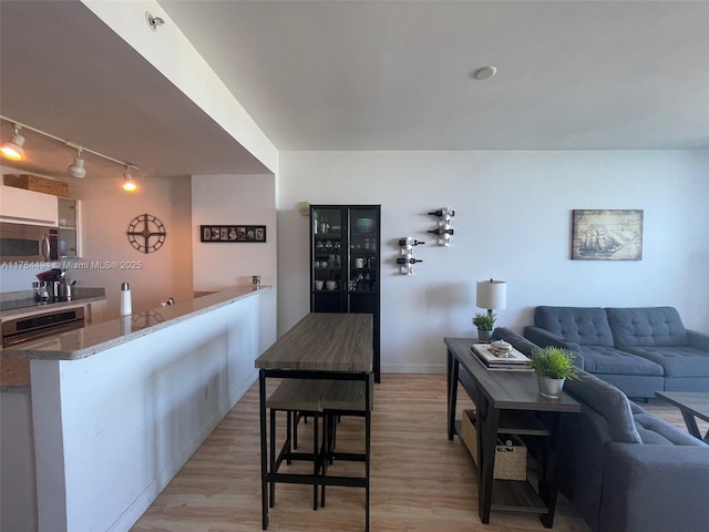 living area featuring light wood-type flooring and baseboards