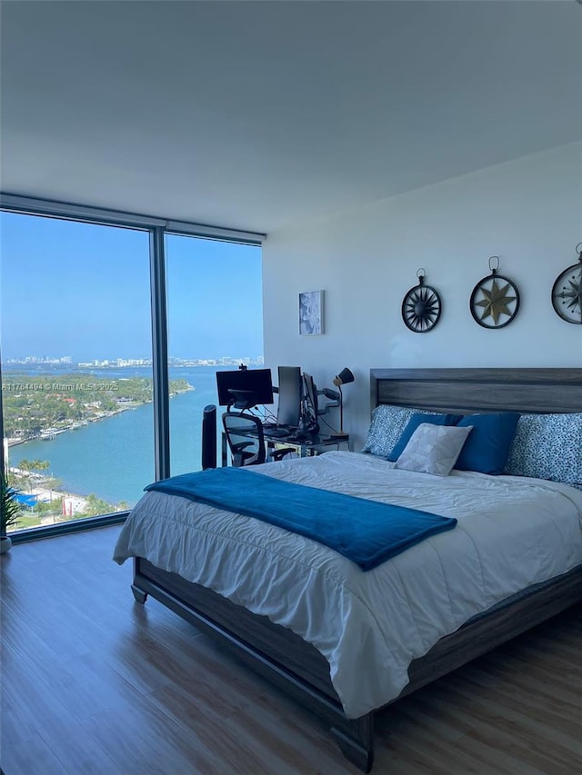 bedroom with expansive windows and wood finished floors