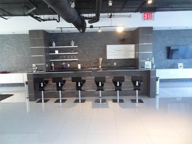 bar featuring decorative backsplash, rail lighting, and tile patterned flooring