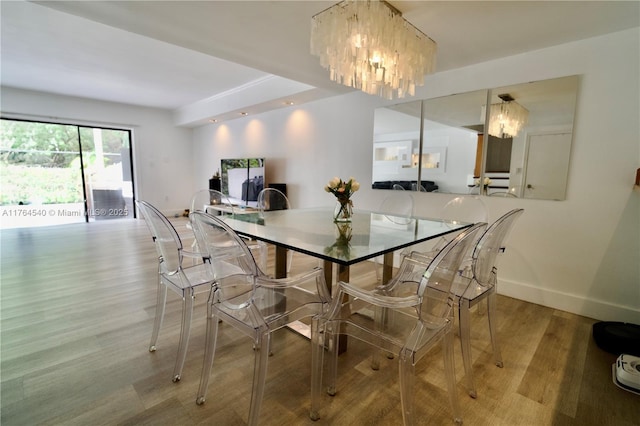 dining room featuring a notable chandelier, wood finished floors, and baseboards