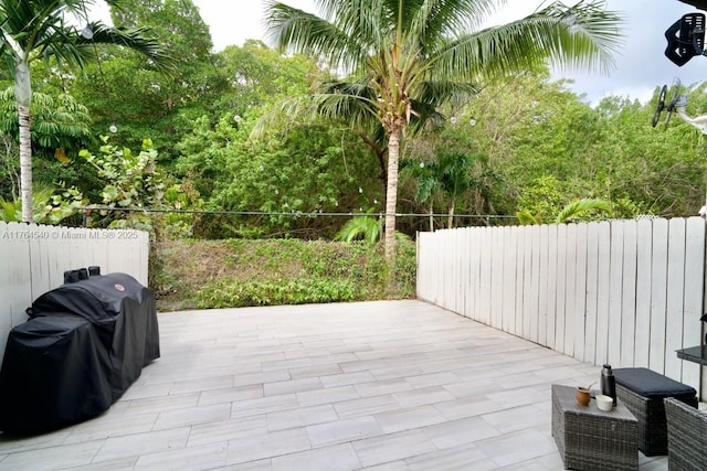 view of patio with a grill and fence