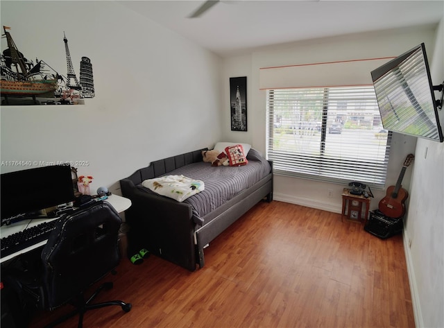 bedroom with baseboards and wood finished floors