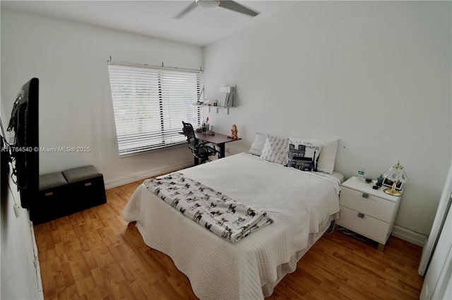 bedroom with ceiling fan, baseboards, and wood finished floors