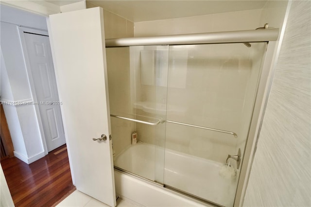 full bathroom featuring shower / bath combination with glass door and wood finished floors