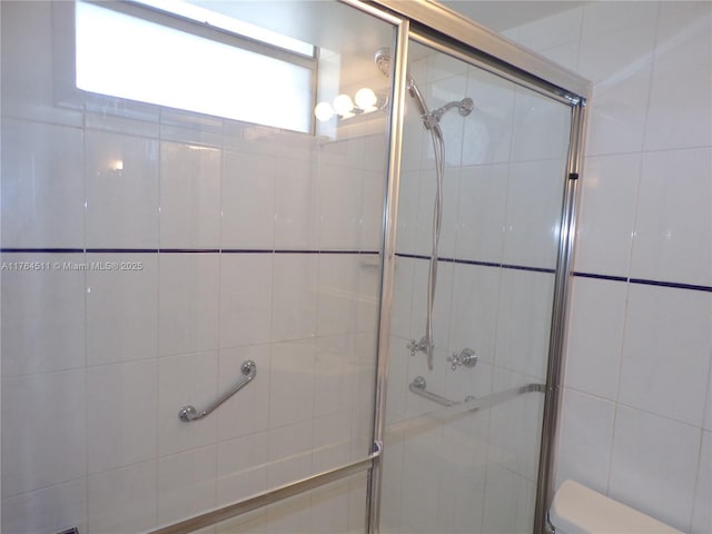 full bath with toilet and a shower stall