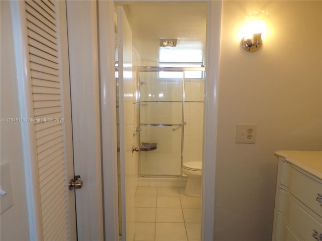 full bathroom featuring toilet, a stall shower, vanity, and tile patterned flooring