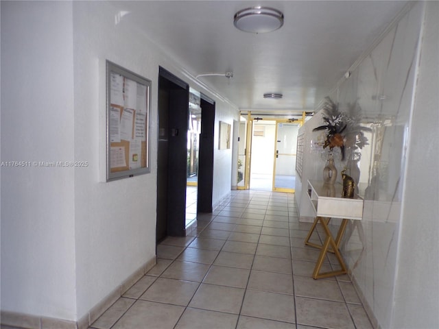 hall with light tile patterned floors and elevator