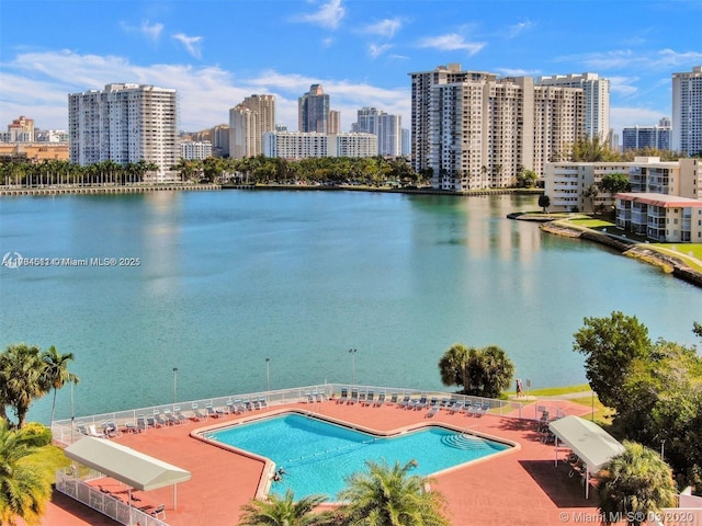 community pool featuring a water view, a city view, and a patio