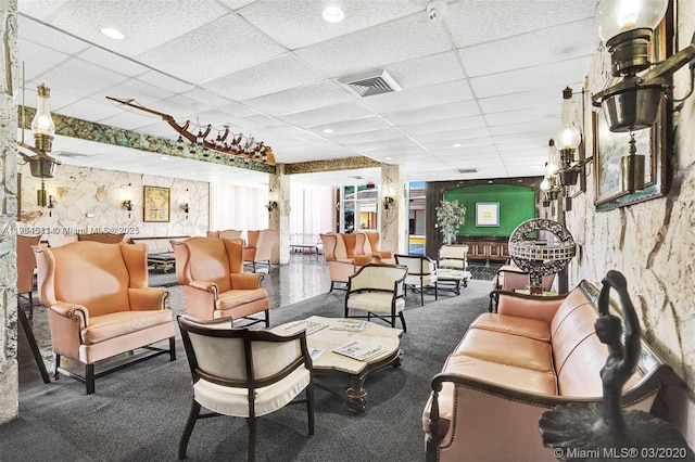 interior space with a drop ceiling, visible vents, and carpet floors