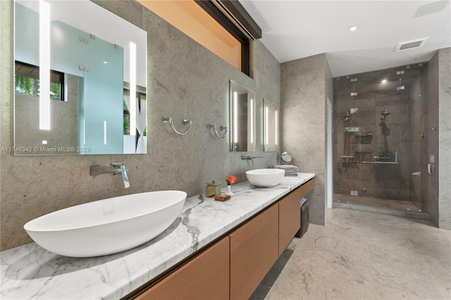 full bath featuring a sink, visible vents, marble finish floor, and a shower stall